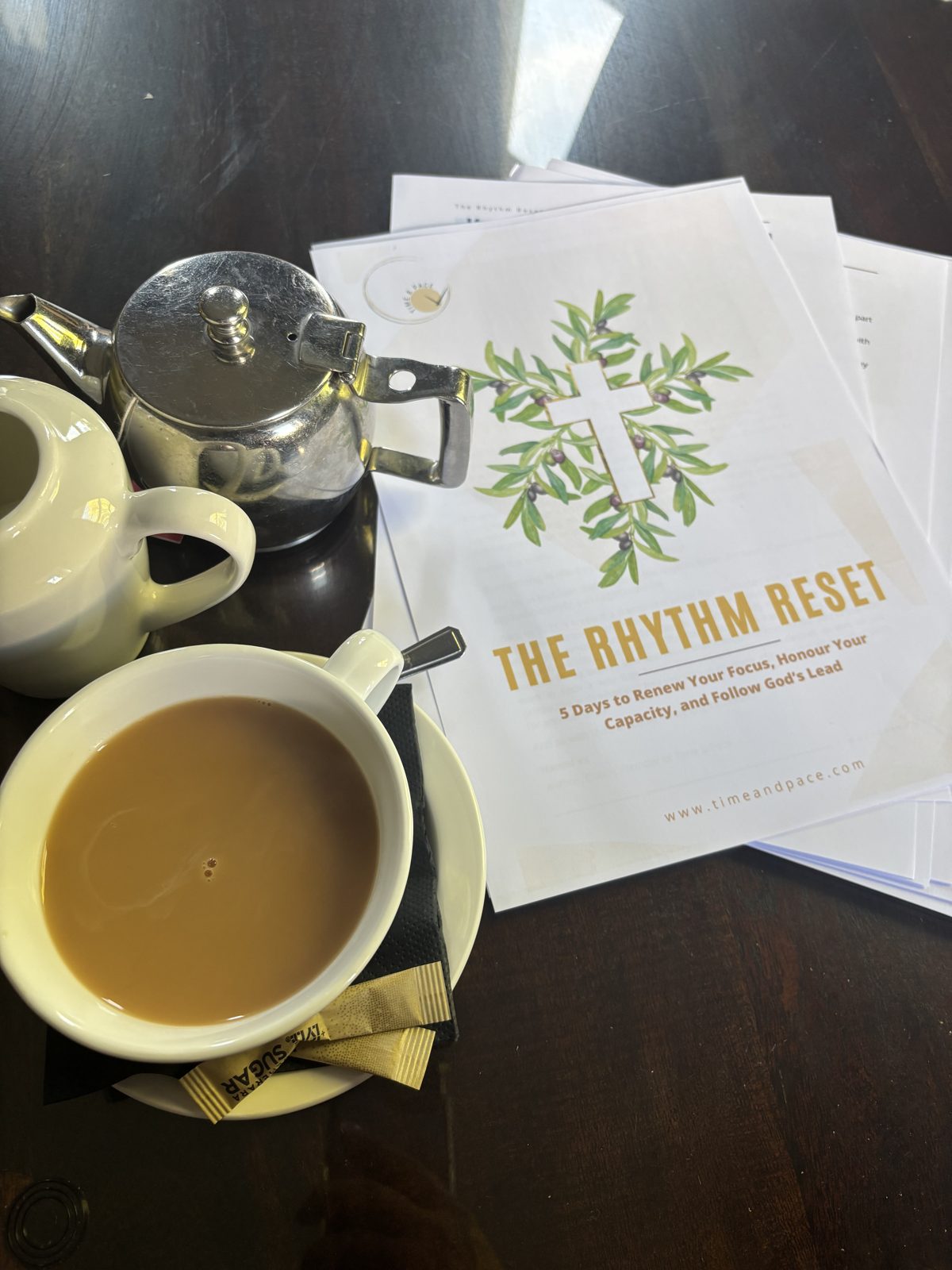 The Rhythm Reset printed workbook beside a cup of tea